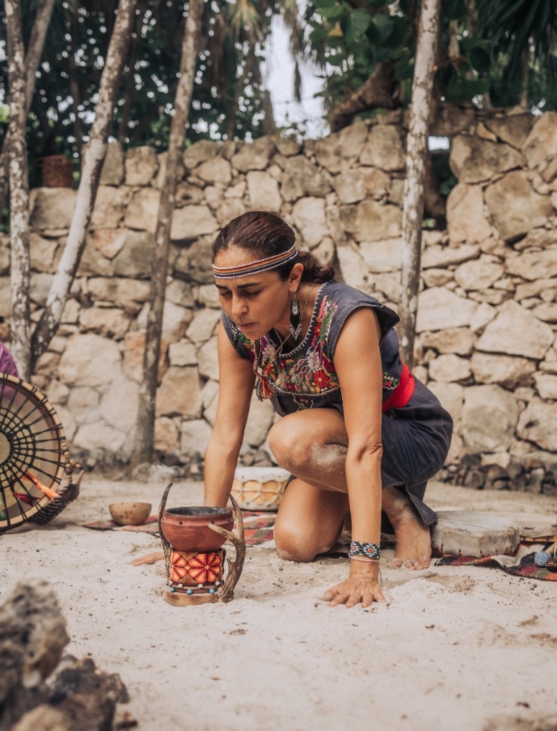 Facilitator leading a traditional ceremony on sand